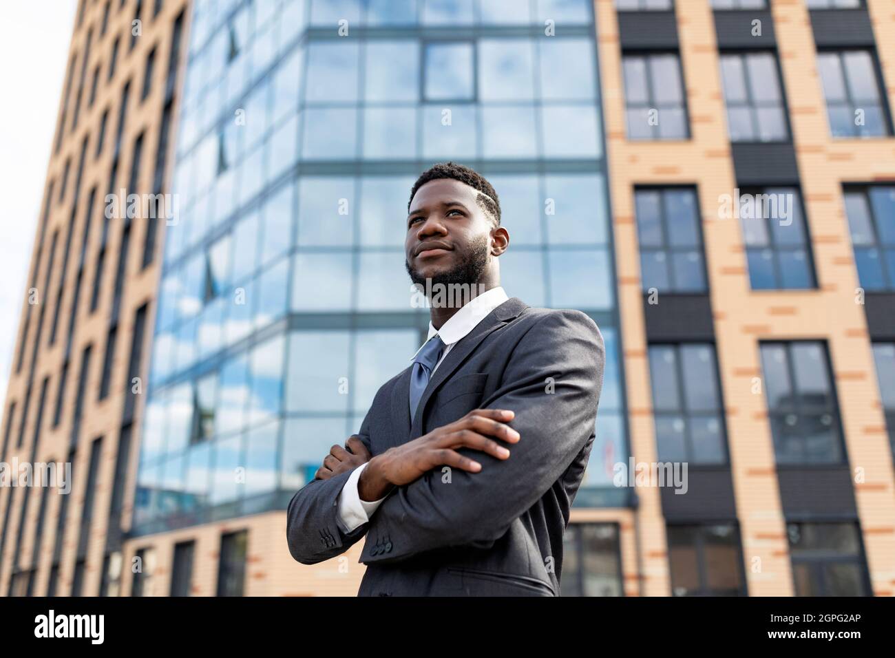 Handsome african american businessman in suit posing with crossed arms