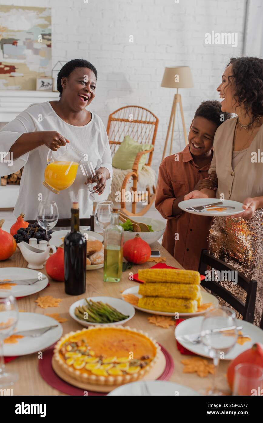 Smiling african american family with kid serving thanksgiving dinner