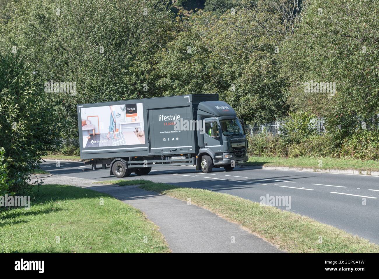 Lifestyle Flooring DAF LF delivery lorry travelling on an uphill country A Road. For UK driver shortages, good deliveries during Covid, & UK transport Stock Photo