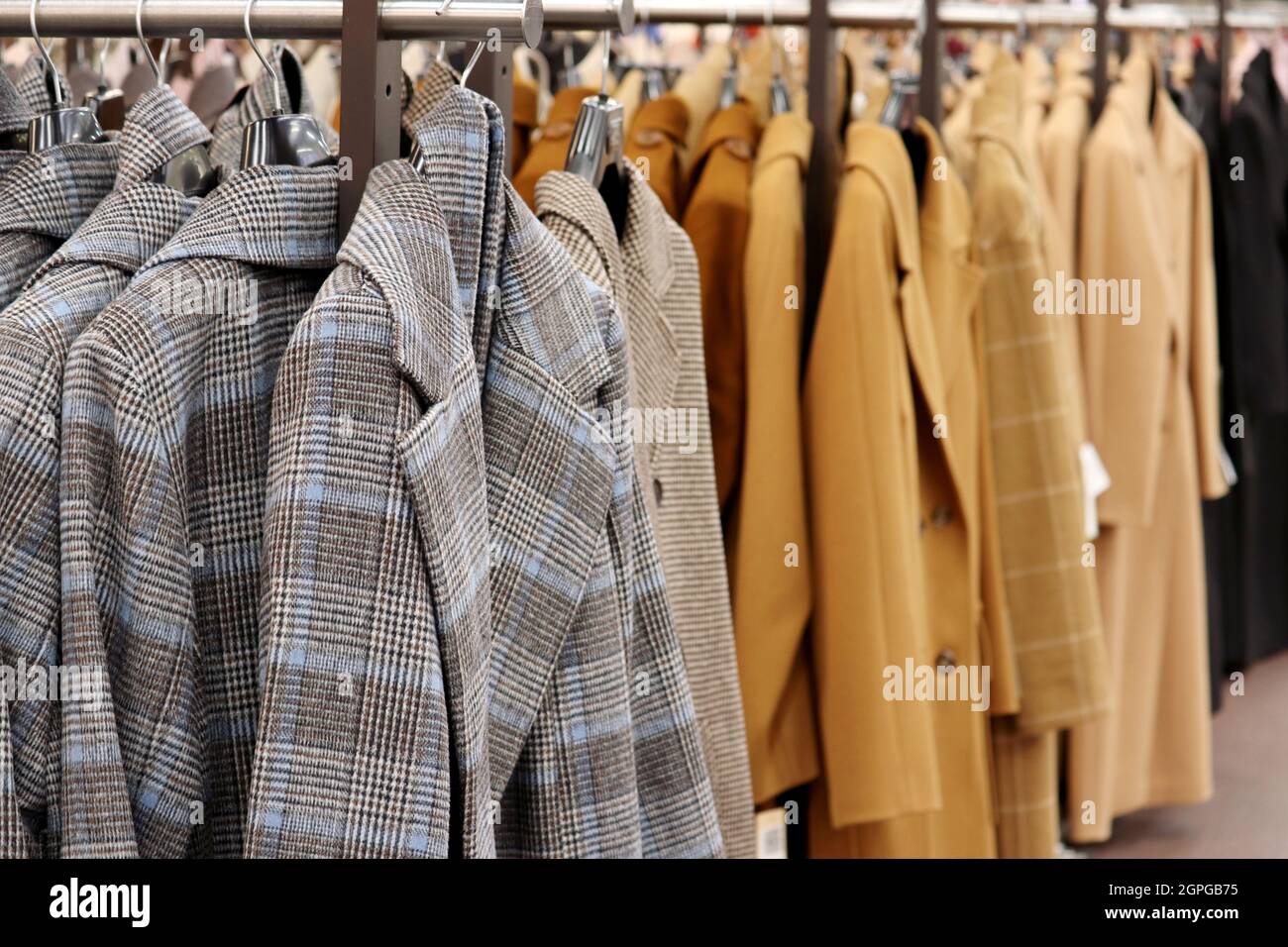Female coats in a row on a hanger in the store. New autumn fashion collection Stock Photo