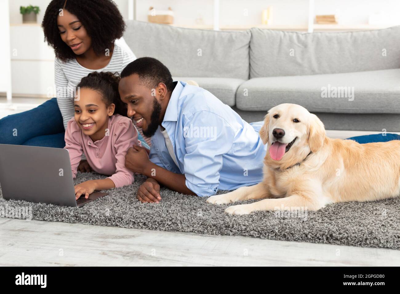 Young black family with dog using laptop Stock Photo
