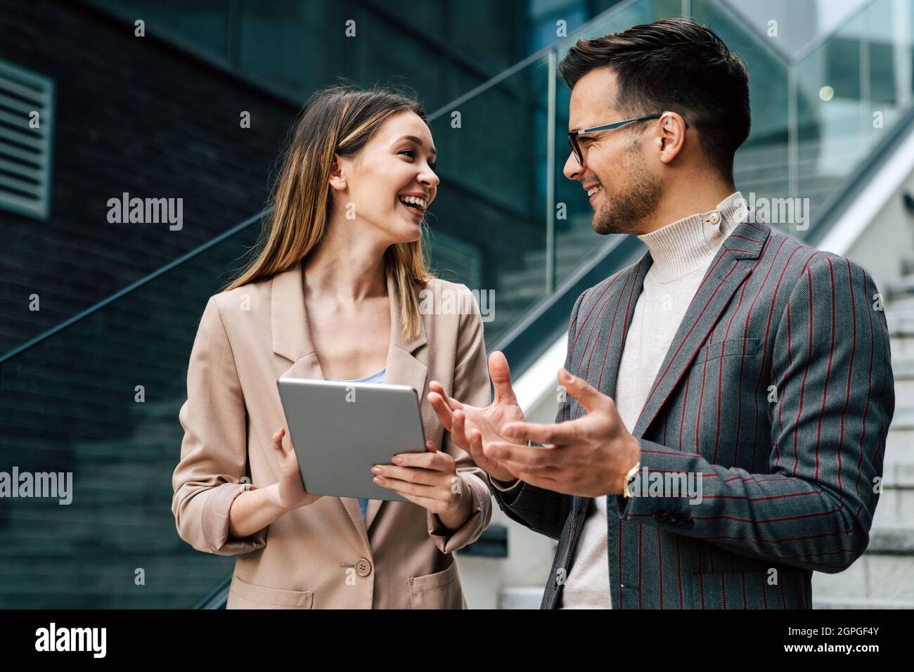 Portrait of successful business people working, talking together in urban background. Stock Photo