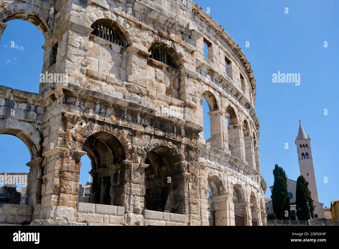 Croatia, Istria, Adriatic coast, Pula, the Roman amphitheater or Coliseum of Pula, built in the 1st century, during the reign of the emperor Augustus and the bell tower of Saint-Antoine chuch Stock Photo
