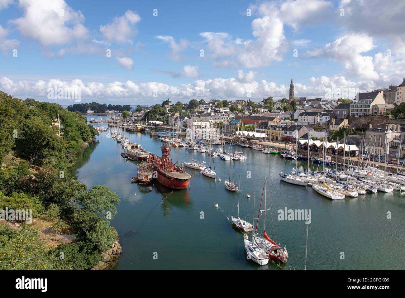 France, Finistere, Cornouaille, Douarnenez, the docks of Port Rhu with ships in the harbour museum and Sacred Heart church in the background Stock Photo