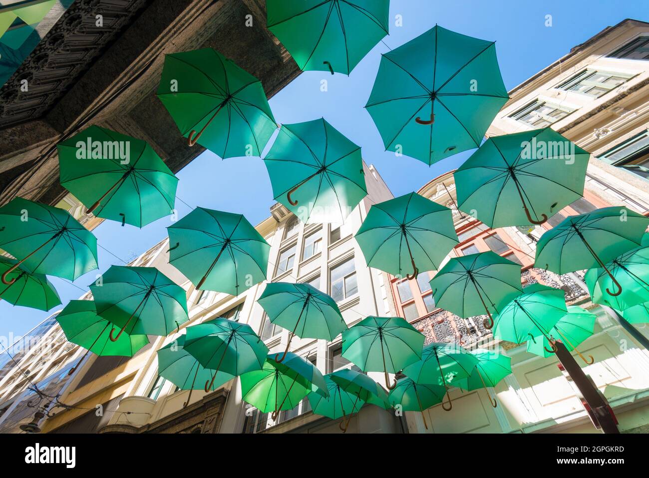 Decorative Green Umbrellas Hanging Between Buildings in the City Stock