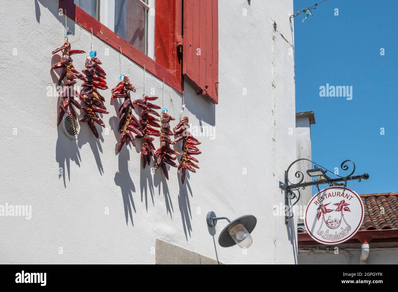 France, Pyrenees Atlantiques, Pays Basque, Espelette, chillies drying in the sun in front of a traditional house Stock Photo