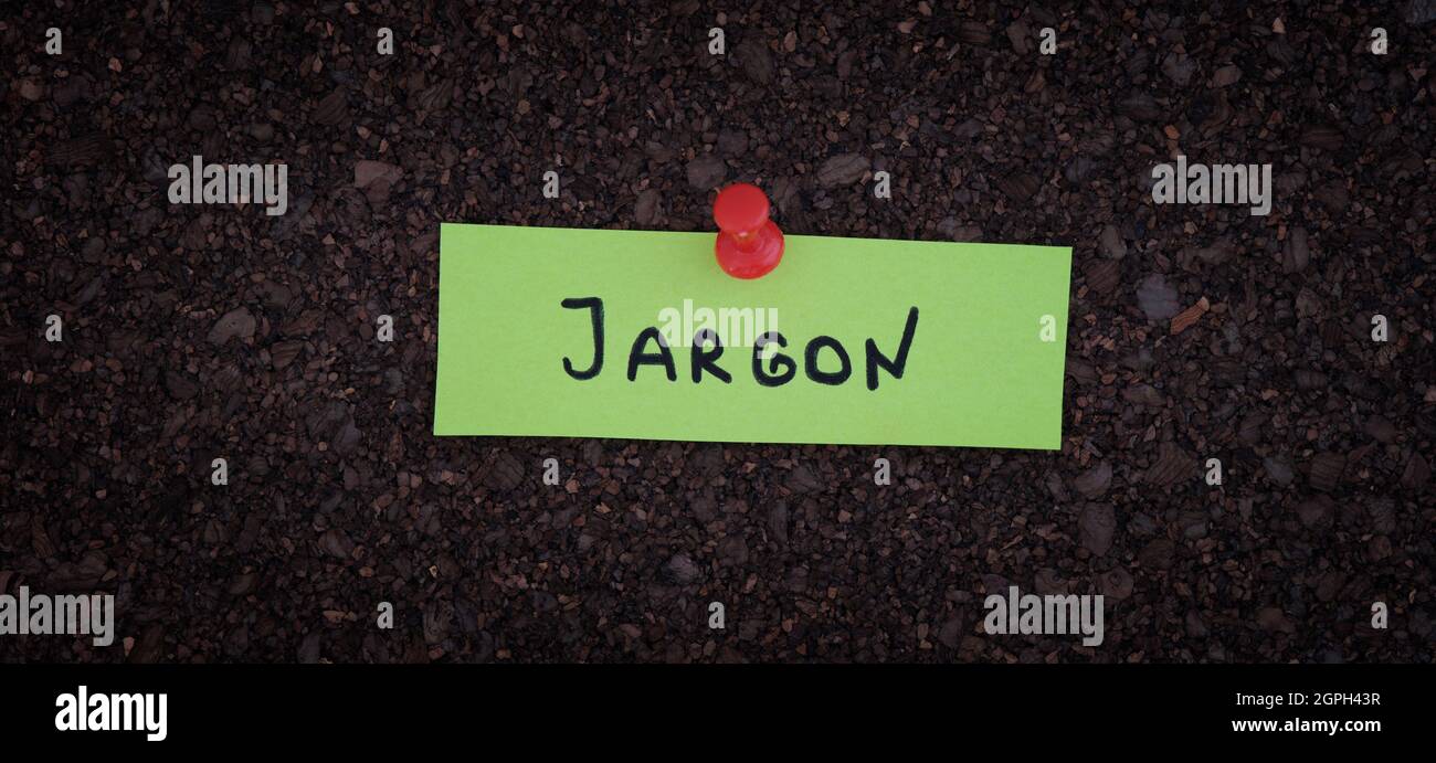 A sticky note with the word Jargon on it pinned to a cork board. Close up. Stock Photo