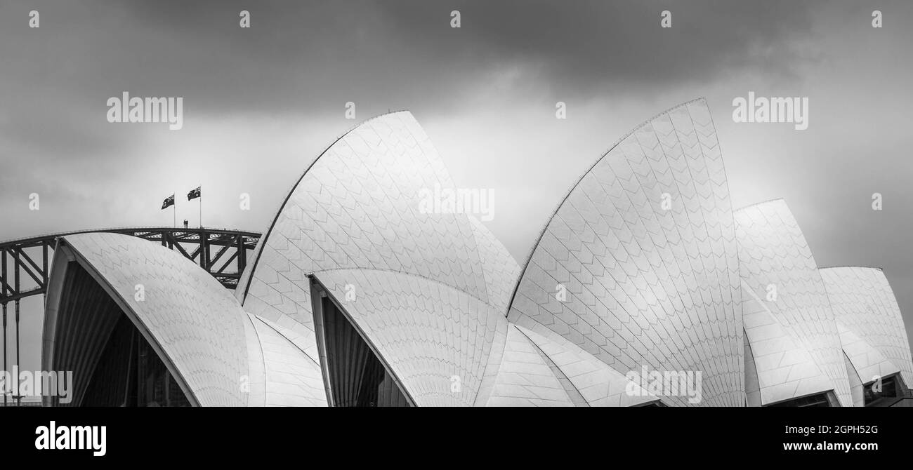 Monochrome image of Sydney opera house and its shell design roof with glimpse of the bridge. No people. Stock Photo