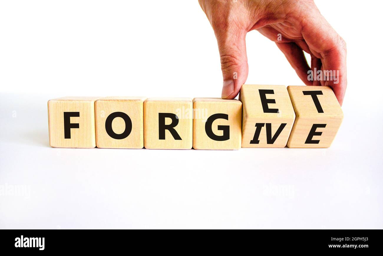 Forgive and forget symbol. Businessman turns wooden cubes and changes the word 'forgive' to 'forget'. Beautiful white background, copy space. Business Stock Photo