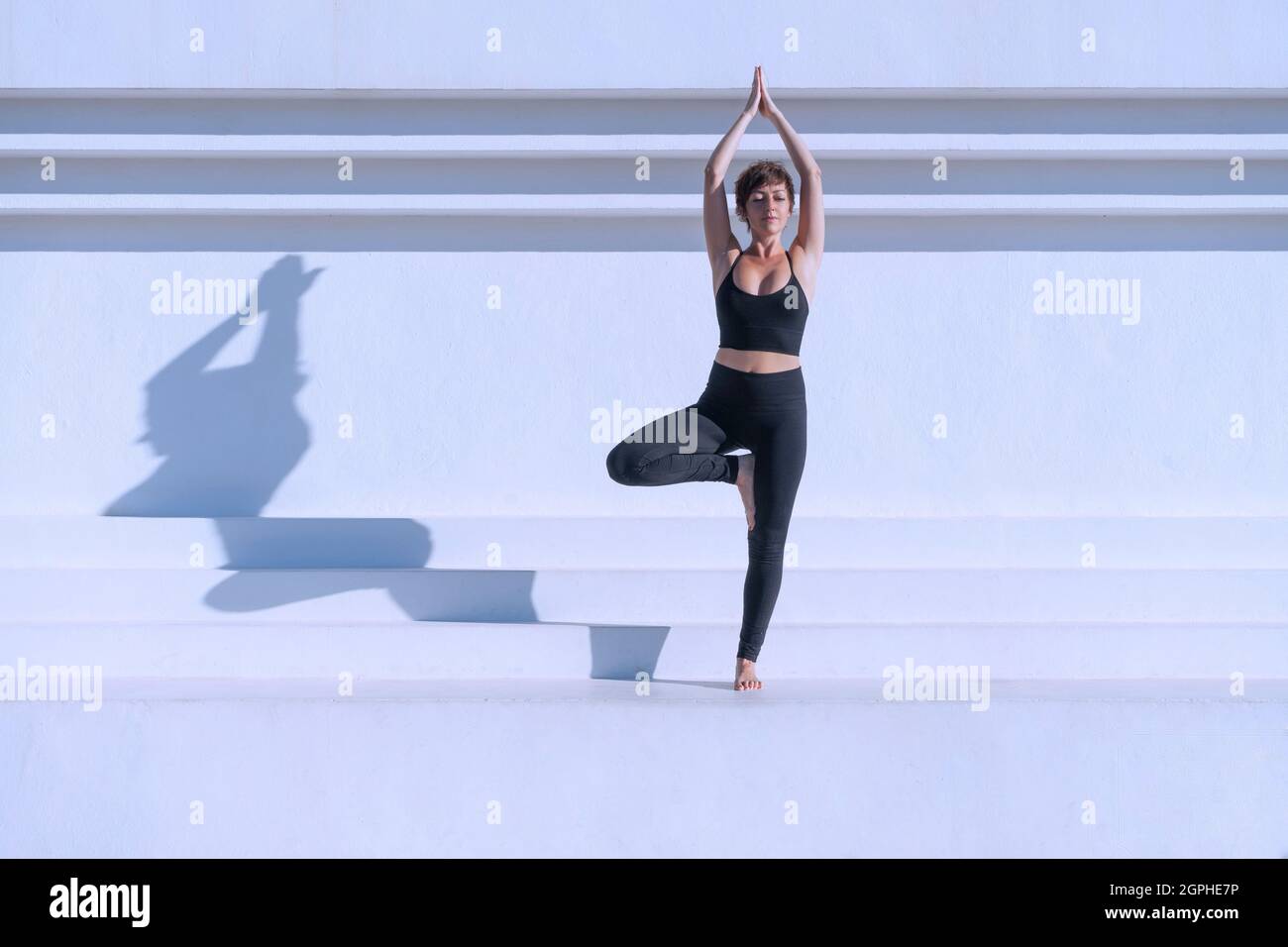 Woman doing yoga tree pose outdoors Stock Photo - Alamy