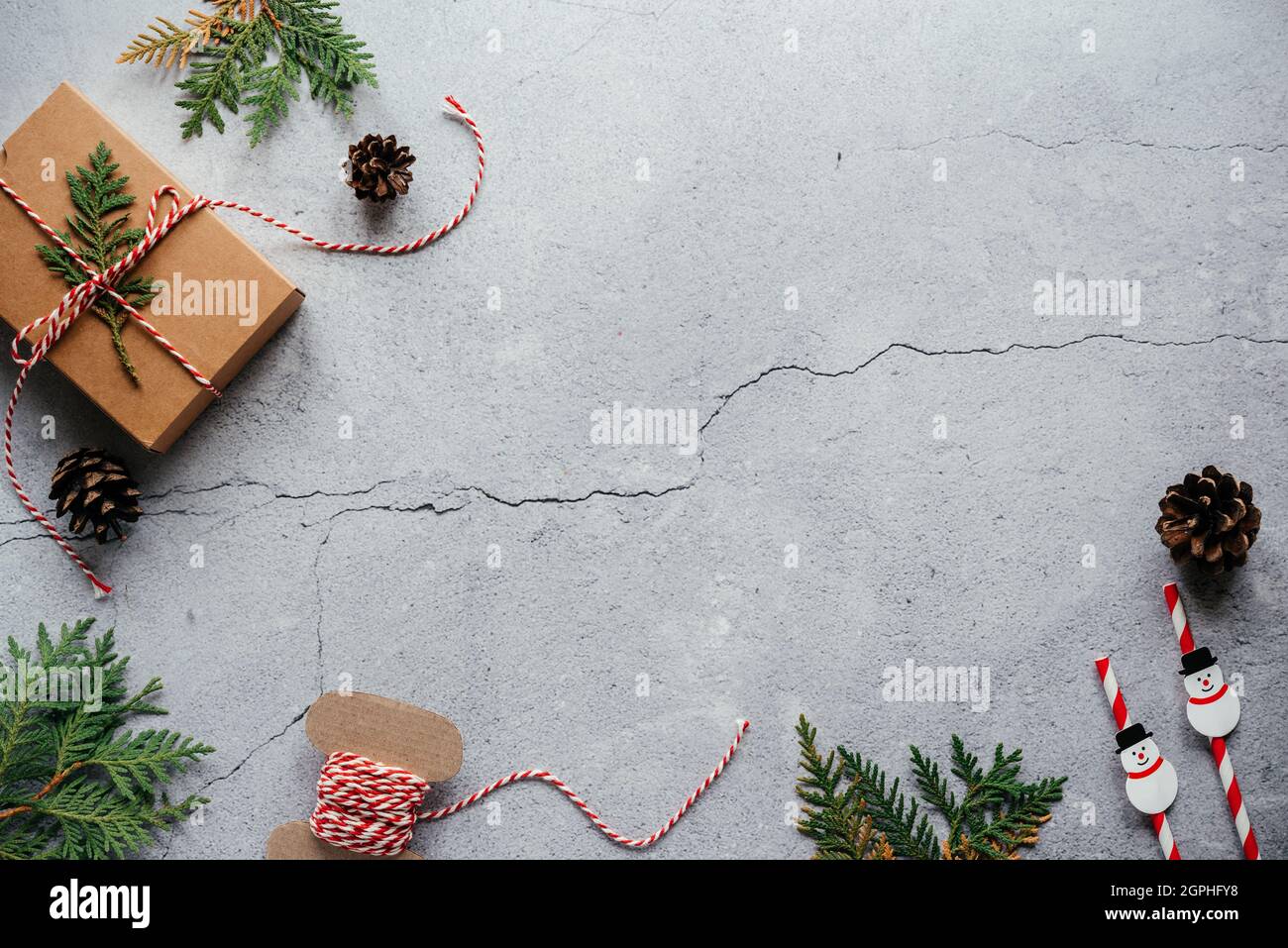 Christmas background with thuja branches, gift box, and pine cones with copy space Stock Photo