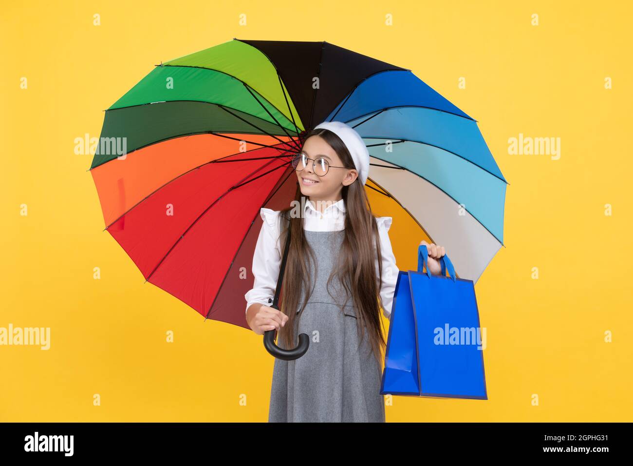 seasonal sale. teen kid under colorful parasol. kid beret with rainbow umbrella. autumn season. Stock Photo