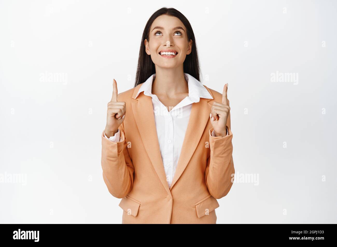 Excited saleswoman pointing and looking up, reading advertisement ...