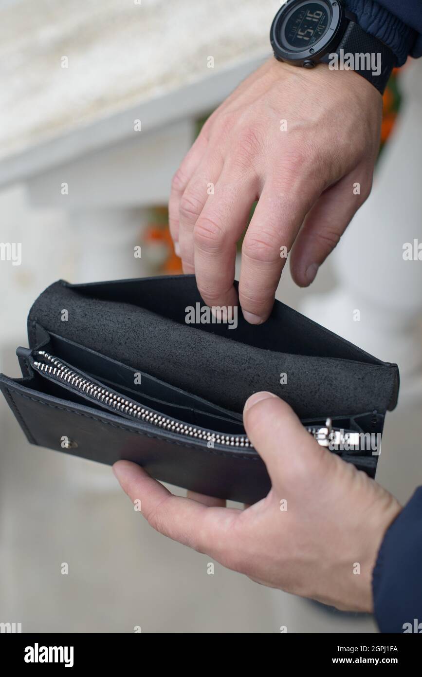 Man holding an empty black leather wallet Stock Photo