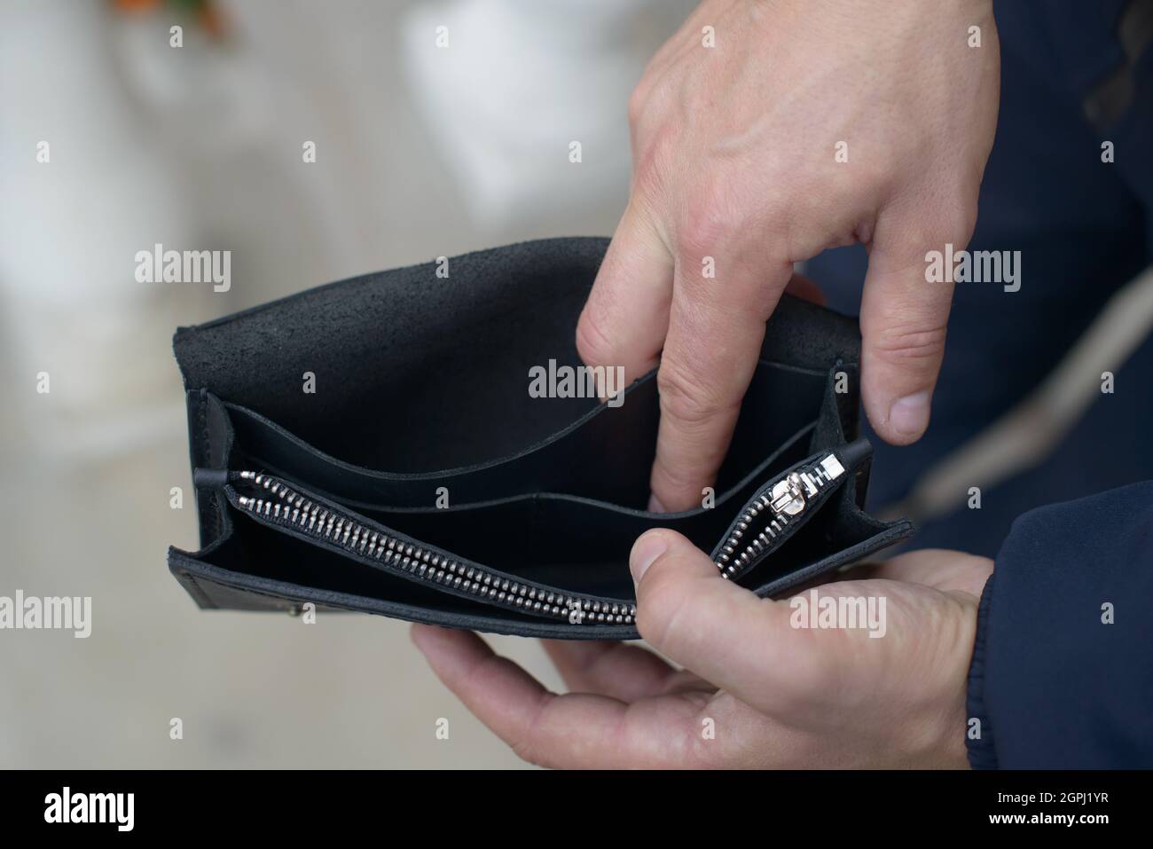 Man holding an empty black leather wallet Stock Photo