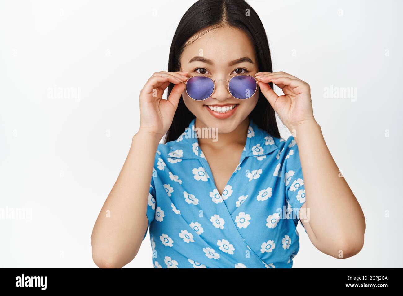 Stylish asian girl wearing sunglasses and blue dress, smiling happy at ...