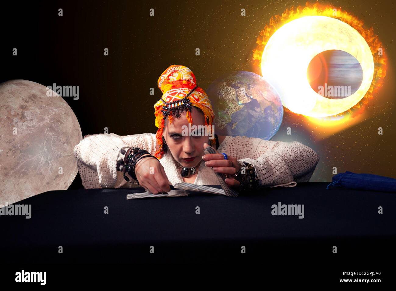 Mystical arts connoisseur woman in fourtion teller card reading based on millennial knowledge of planets and astrology in Mexico City with planet eart Stock Photo