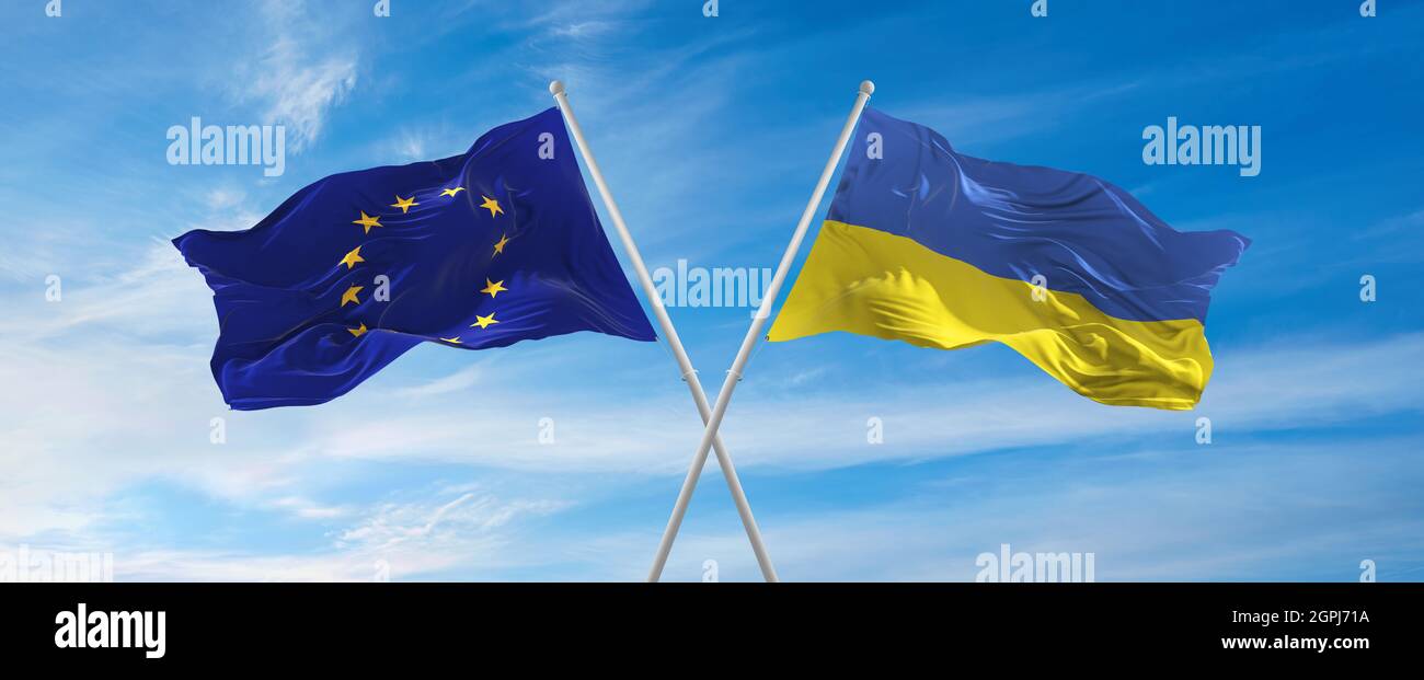 flags of European Union and Ukraine waving in the wind on flagpoles ...