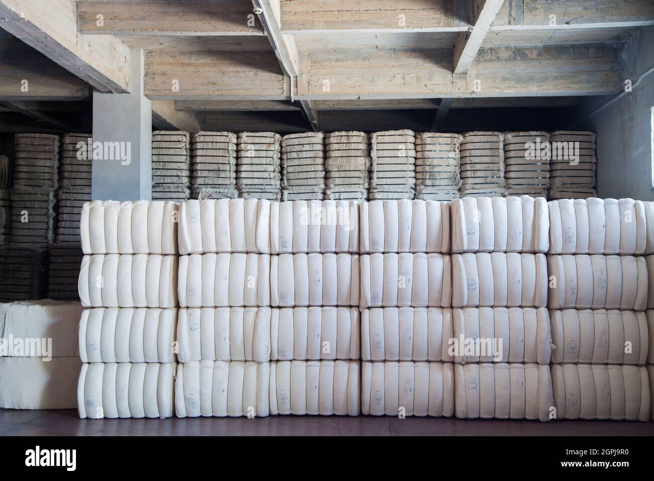 Raw cotton bales in textile factory. Stock Photo