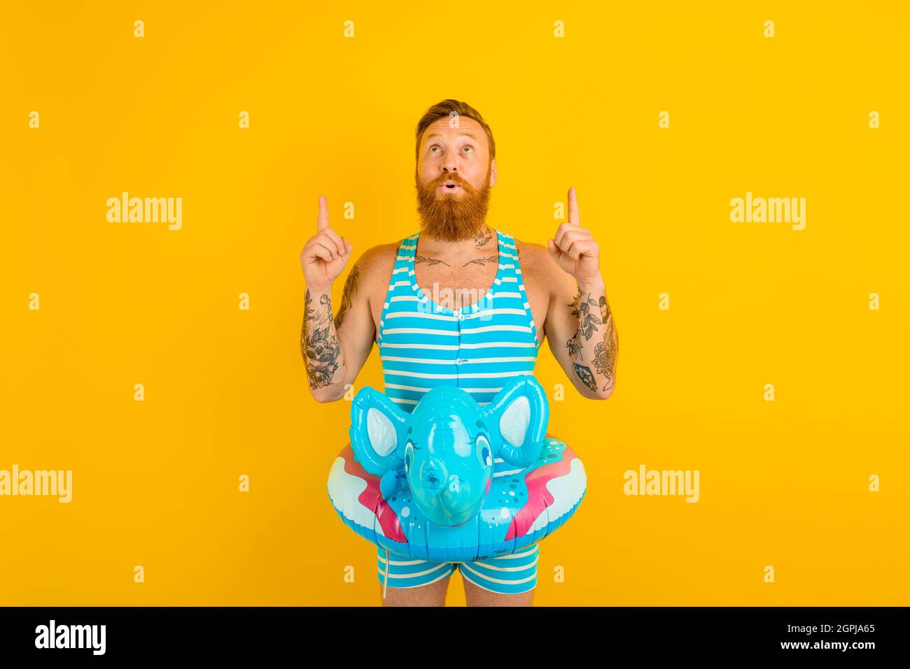 man with inflatable donut with elephant is ready to swim Stock Photo