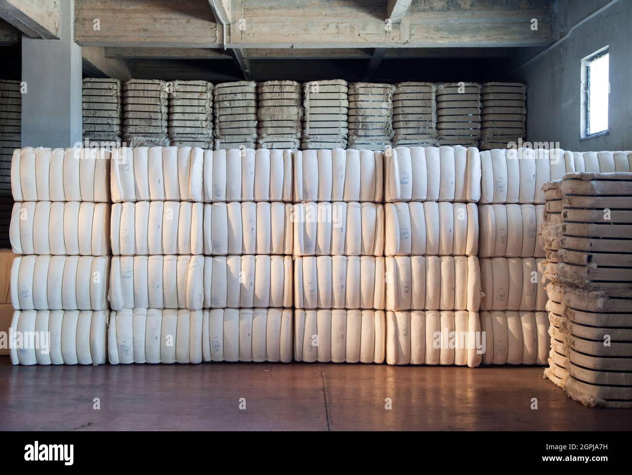 Raw cotton bales in textile factory. Stock Photo