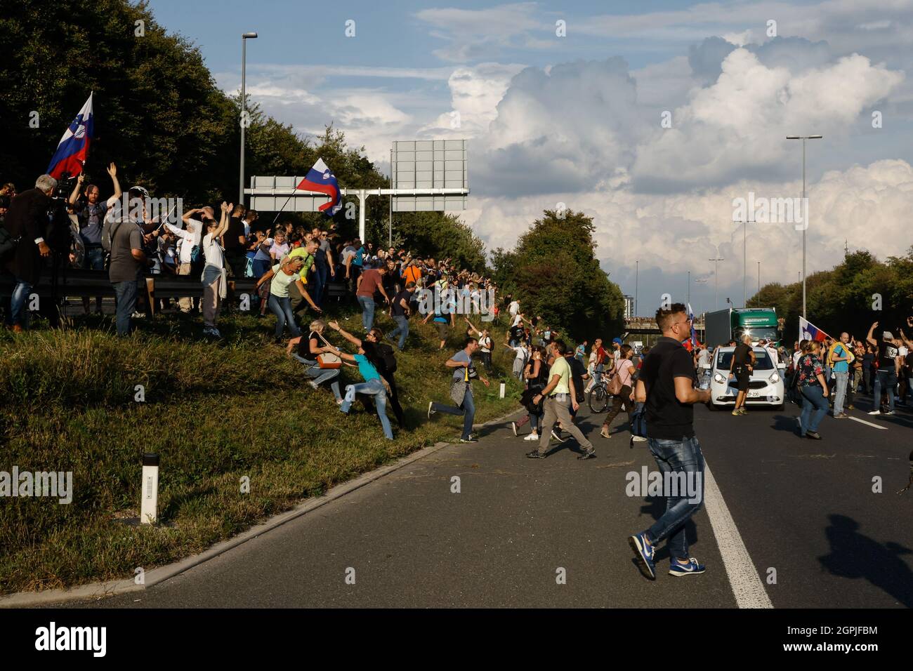 Ljubljana, Slovenia. 29th Sep, 2021. Protesters run onto the road as try to block the highway during the demonstration.Thousands of people protested against the government, covid measures, wearing of face masks, vaccines and RVT green pass (Recovered-Vaccinated-Tested) condition in Ljubljana, Slovenia. (Photo by Luka Dakskobler/SOPA Images/Sipa USA) Credit: Sipa USA/Alamy Live News Stock Photo