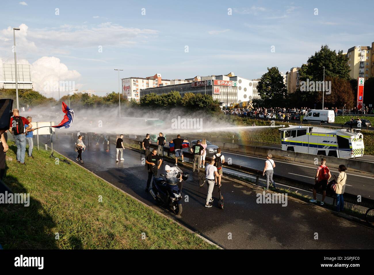 Ljubljana, Slovenia. 29th Sep, 2021. Police force uses a water cannon as protesters try to block the highway during the demonstration.Thousands of people protested against the government, covid measures, wearing of face masks, vaccines and RVT green pass (Recovered-Vaccinated-Tested) condition in Ljubljana, Slovenia. (Photo by Luka Dakskobler/SOPA Images/Sipa USA) Credit: Sipa USA/Alamy Live News Stock Photo