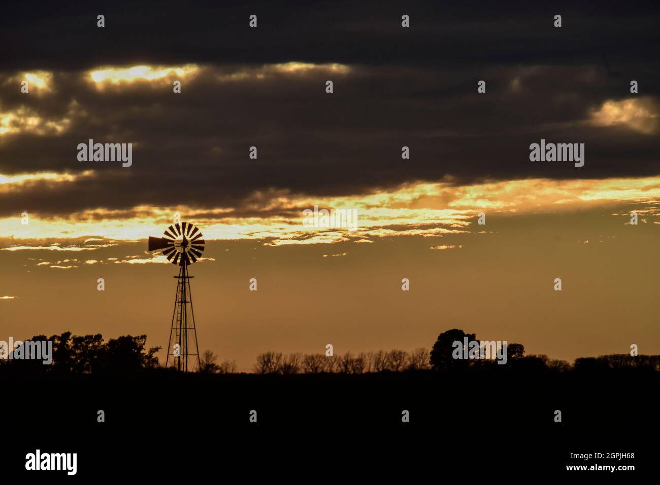 Windmill at sunset in the Argentine countryside, Pampas province, Patagonia, Argentina. Stock Photo