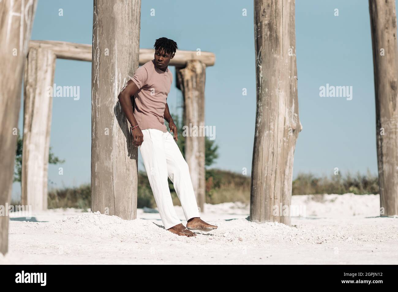Handsome stylish black curly man, man wearing stylish clothes, posing in dry desert, Wild west style, fashion model Stock Photo