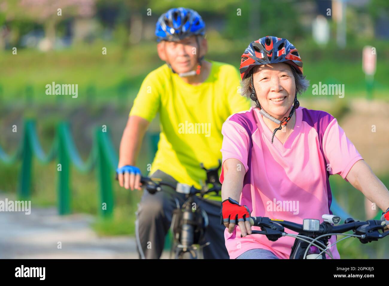 Happy  senior couple exercising with bicycles in the park Stock Photo