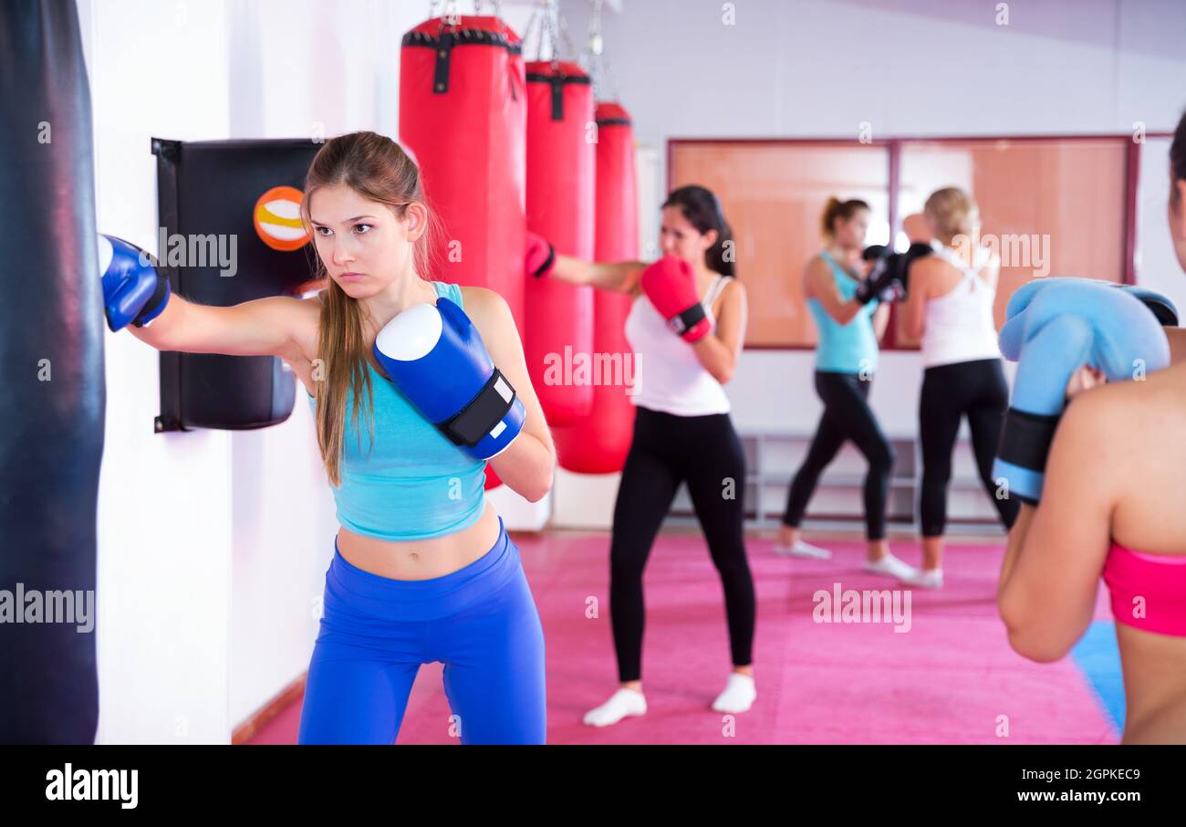 Female is doing exercises with punching bag Stock Photo