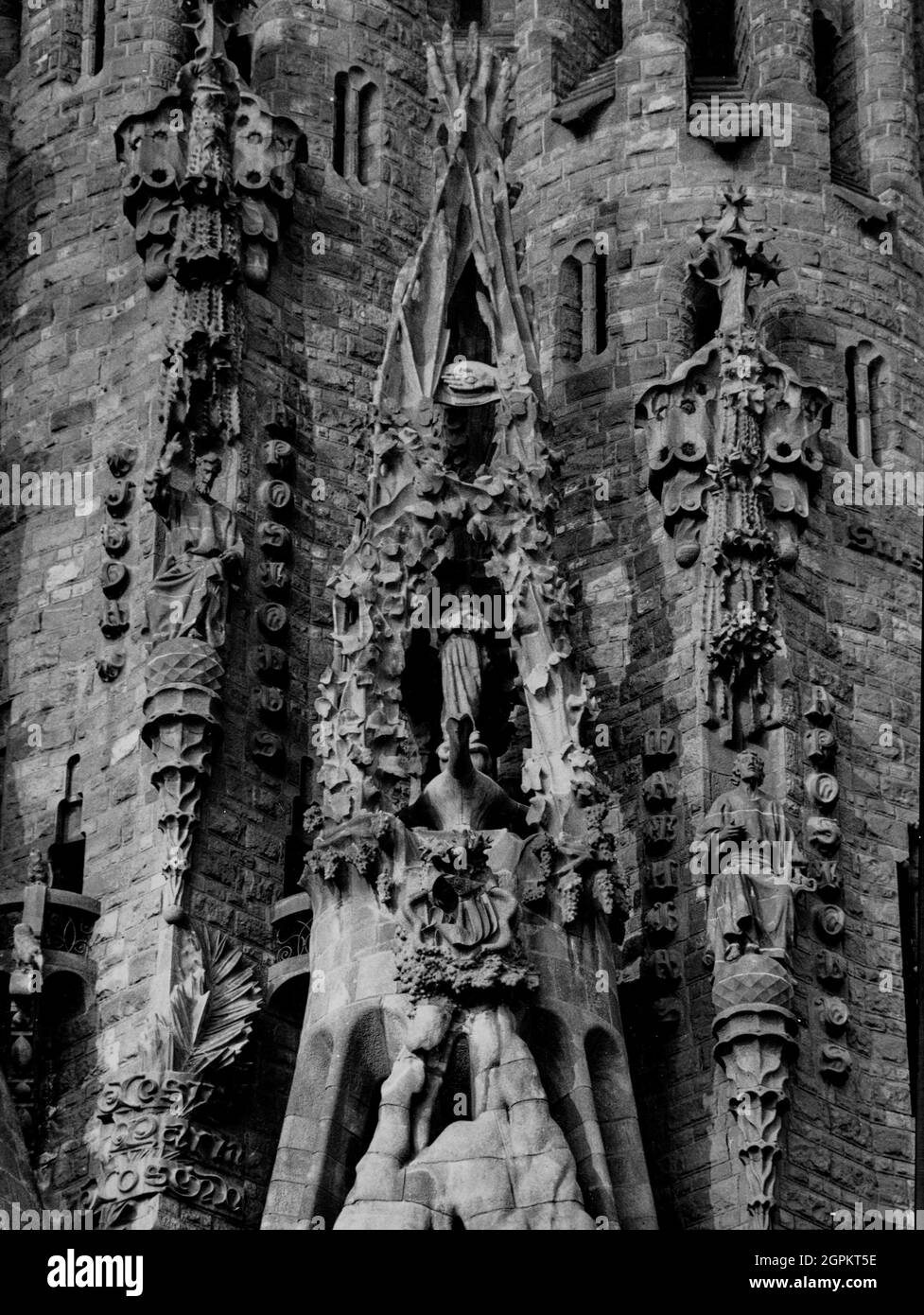 Sagrada Familia (Nativity Facade): portico of the Faith with the Immaculate Conception that is inside a crucible of three pipes that represent the Holy Trinity and on the summit there is the hand with the eye that sees everything as a symbol of Divine Providence, 1934. Author: JOAN MATAMALA FLOTATS. Stock Photo