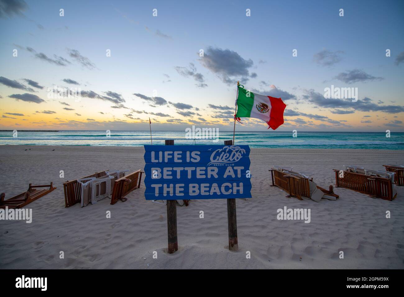 Cielo Beach Club sign with Mexican National Flag waving on Chacmool Beach at sunrise, Cancun, Quintana Roo QR, Mexico. Stock Photo