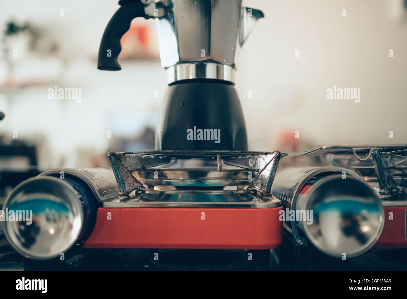 Brewing black moka coffee using moka coffee maker and boiling on stove