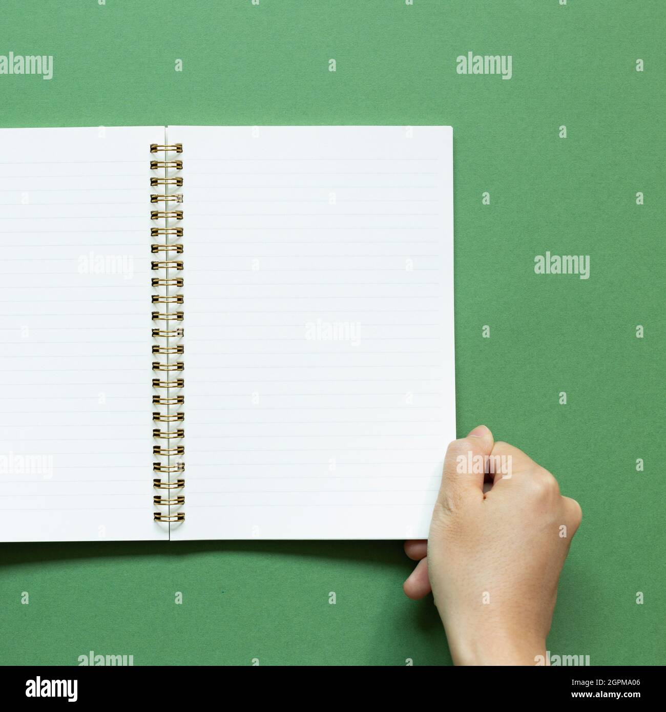 Hand open notebook on green background. top view, copy space Stock ...