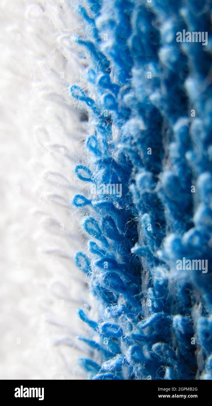 macro zoomed in background of blue and white threads of a cotton fabric kept in the sun on a summer morning Stock Photo