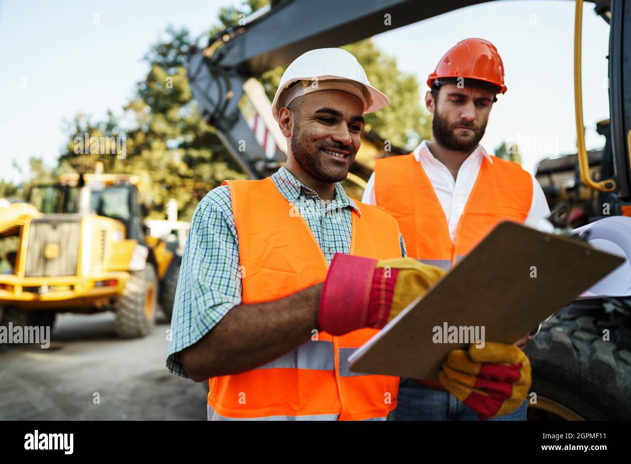 Two men engineers discussing their work standing against construction ...