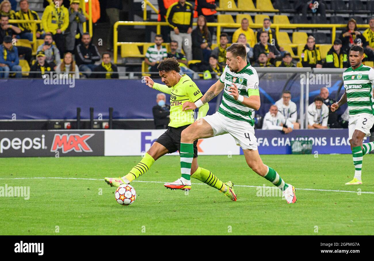 Dortmund, Deutschland. 28th Sep, 2021. Donyell PAINT l. (DO) shoots the  goal to make it 1-0, versus Sebastian COATES r. (LIS), action, football  Champions League, preliminary round 2nd matchday, Borussia Dortmund (DO) -