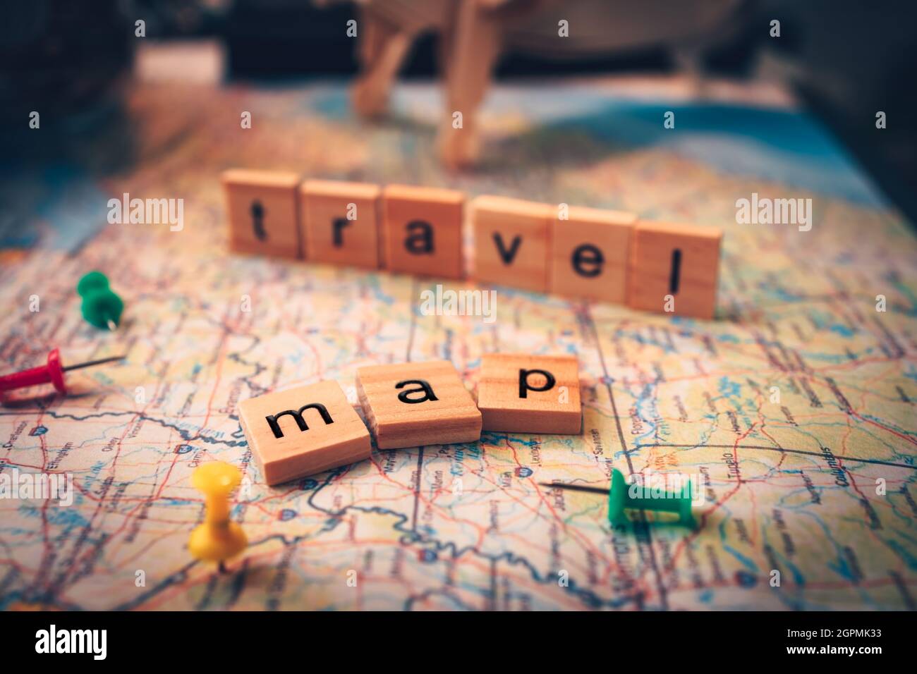 Wood square with word "map" and "travel" on the map. pushpin showing the location of a destination point on a map. Travel plan concept. Stock Photo