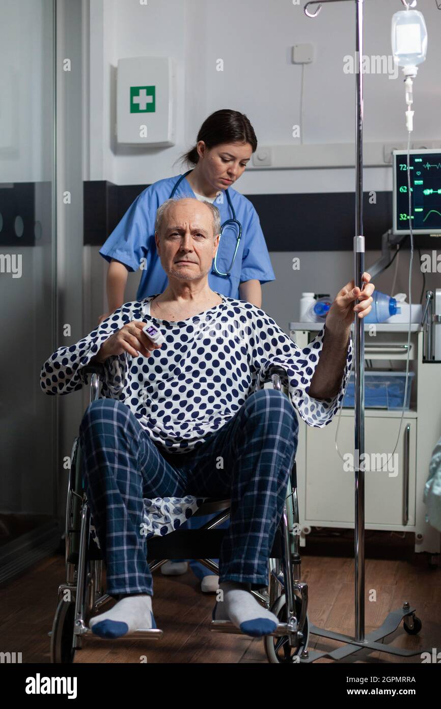 Medical practitioner preparing senior sick hospitalized man in