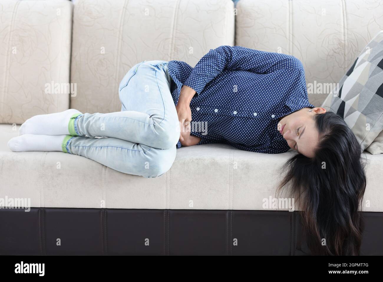 Tired woman lies on couch with abdominal pain Stock Photo Alamy