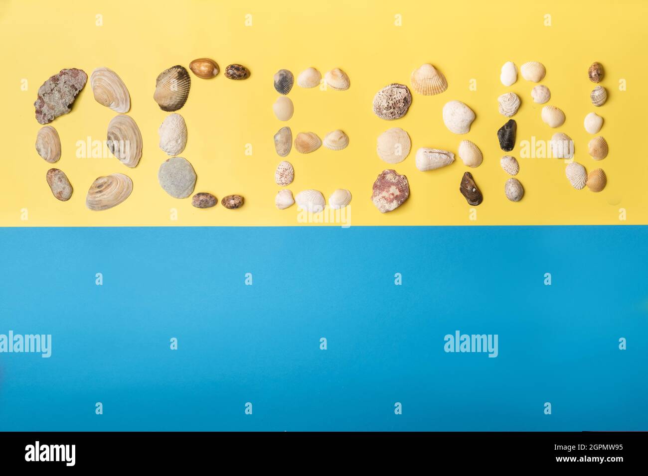The inscription of the word ocean is made of shells on a yellow-blue ...