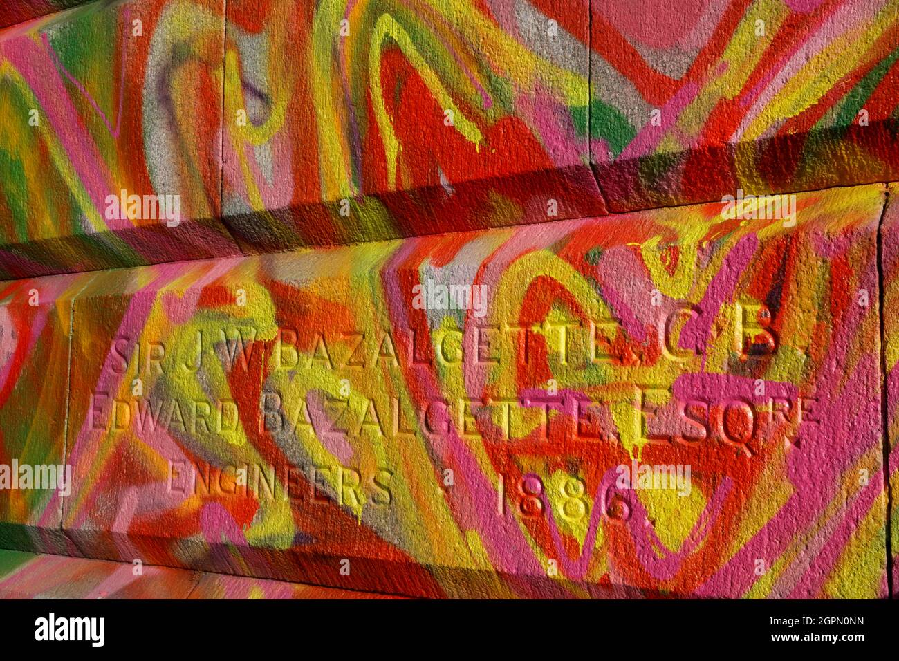Graffiti obscures the inscriptions for engineers JW Bazalgette and Edward Bazalgette on the side of Putney Bridge, Putney, London, UK Stock Photo