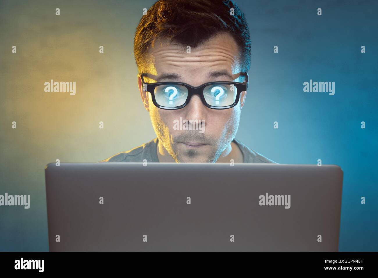 Wondering man in front of a laptop monitor Stock Photo