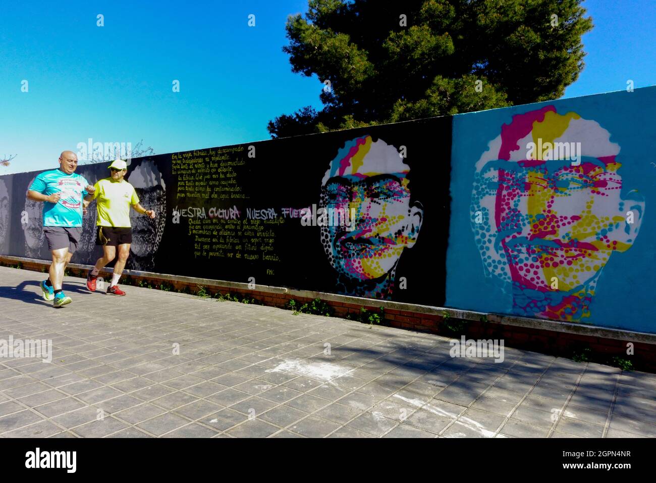 Two men running in Valencia street art Spain graffiti on wall Stock Photo