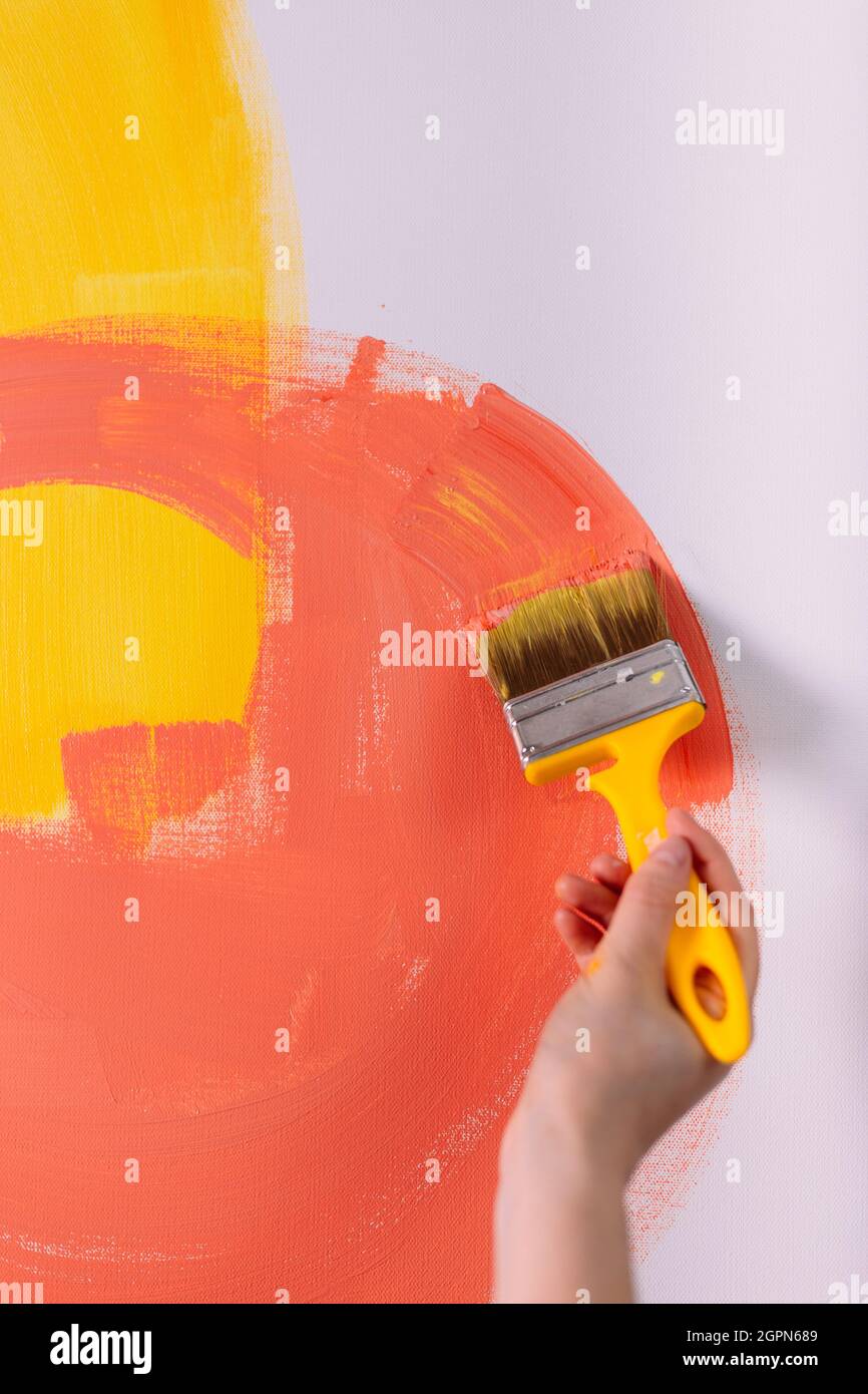 Female hands hold paint brushes. Painting a picture on an easel Stock