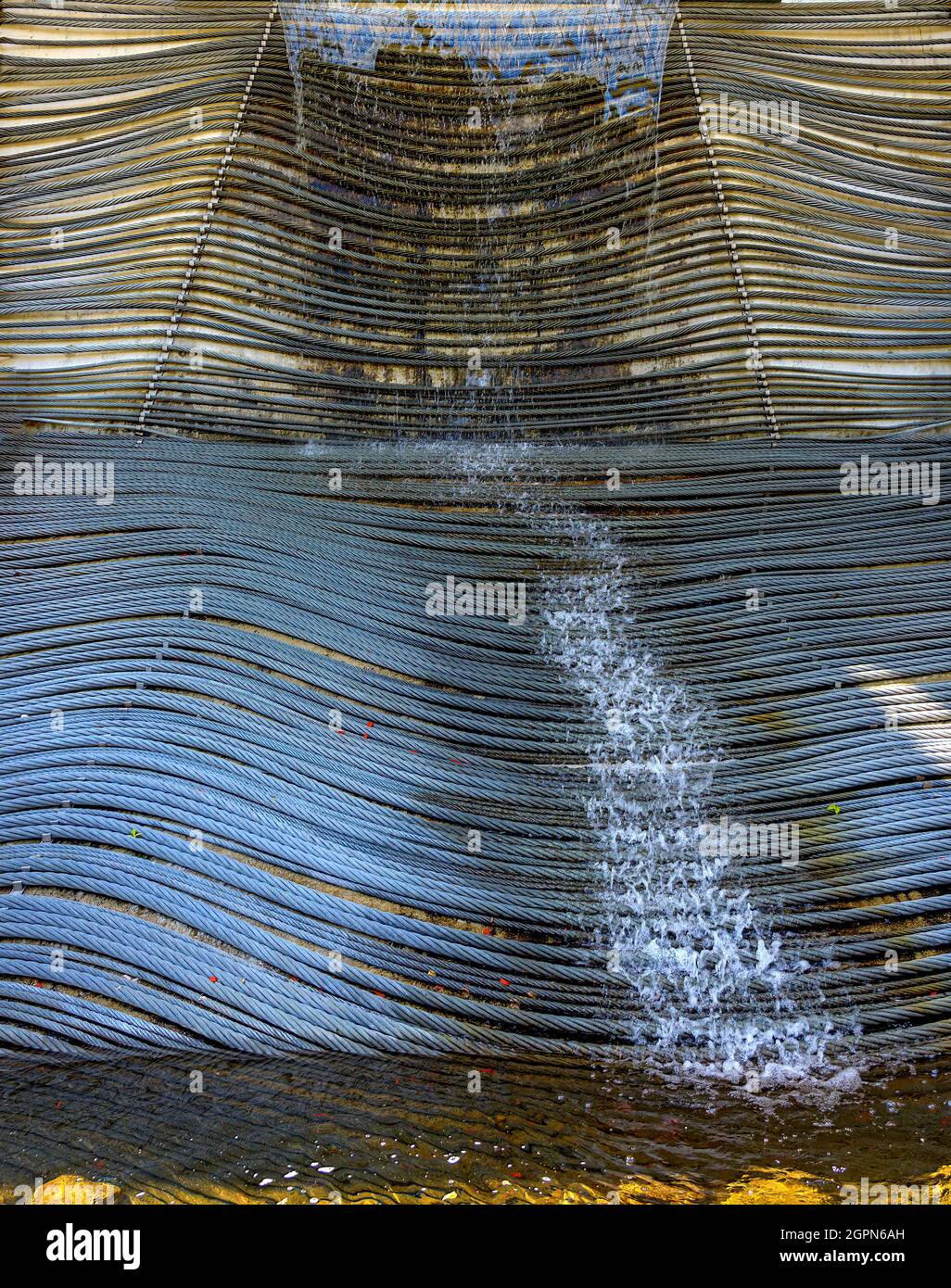 water is splashing over steel cables at an ornamental well in the region Pinzgau, Austria Stock Photo