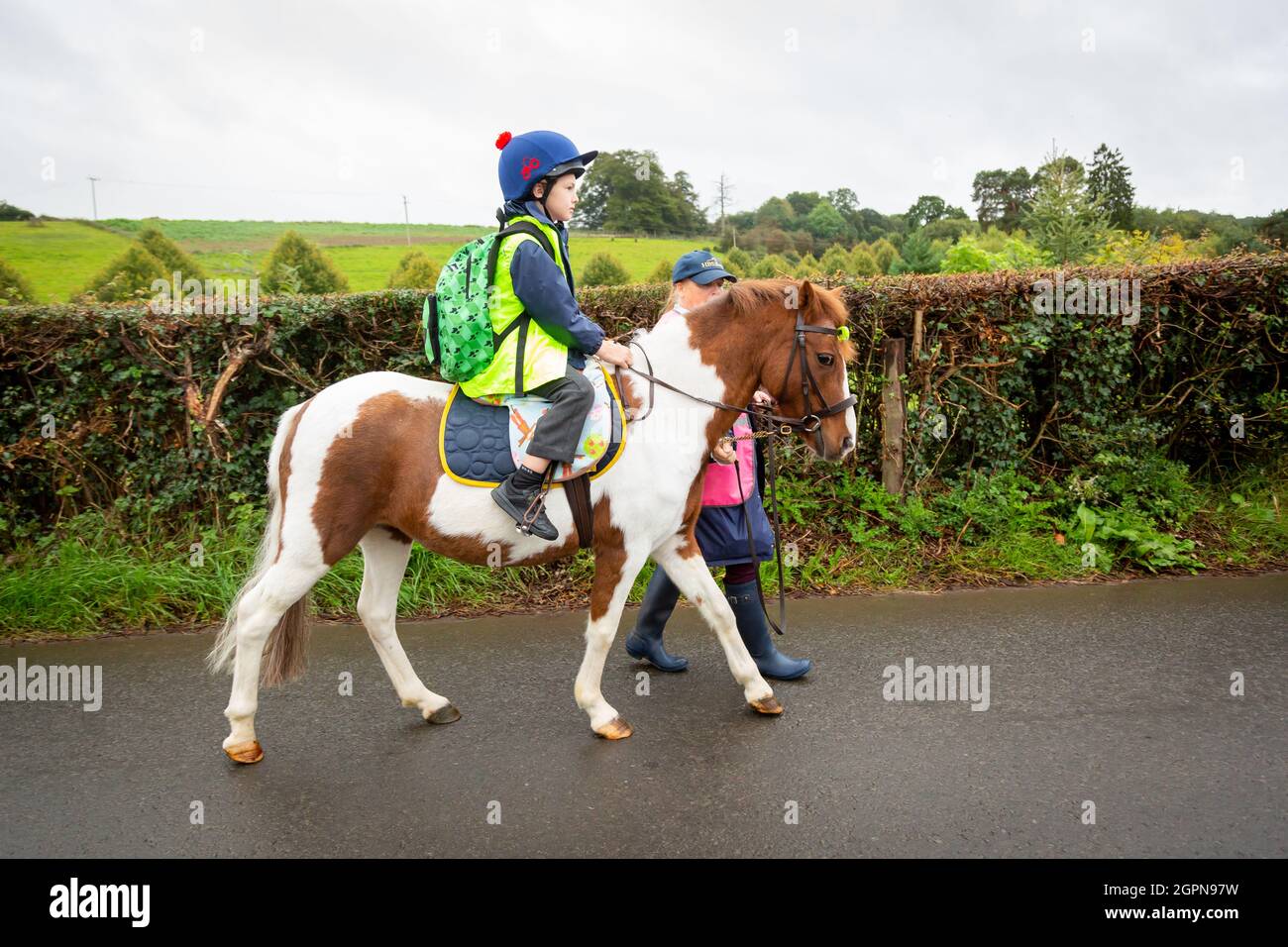 Upper Arley, Worcestershire, UK. 30th Sep, 2021. Grandmother Jane Mundie beats the fuel shortage crisis by using her pony 'Fern' on the school run. Her grandson Henley, 8, confidently rides the pony the two miles to Upper Arley C of E primary school in rural Worcestershire. 'I can't get diesel for my Land Rover at the moment but we don't need to worry too much when the children have our pony, Fern. And it's definitely a fun and green way to get to school,' says Jane. Credit: Peter Lopeman/Alamy Live News Stock Photo