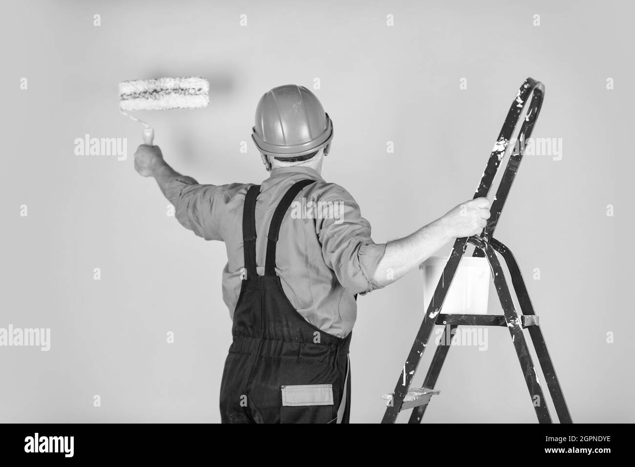 Foreman inspector. senior man painter use roller on ladder. painting