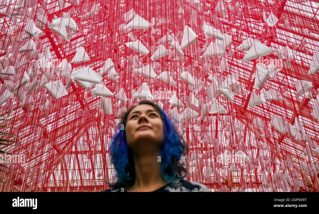 A lady looks at the centrepiece called 'One Thousand Springs' created by Japanese artist Chiharu Shiota during a photocall for the Japan Festival, which is a celebration of the country's breath-taking plants, art and culture, at the Royal Botanic Gardens, Kew, London. Picture date: Thursday September 30, 2021. Stock Photo